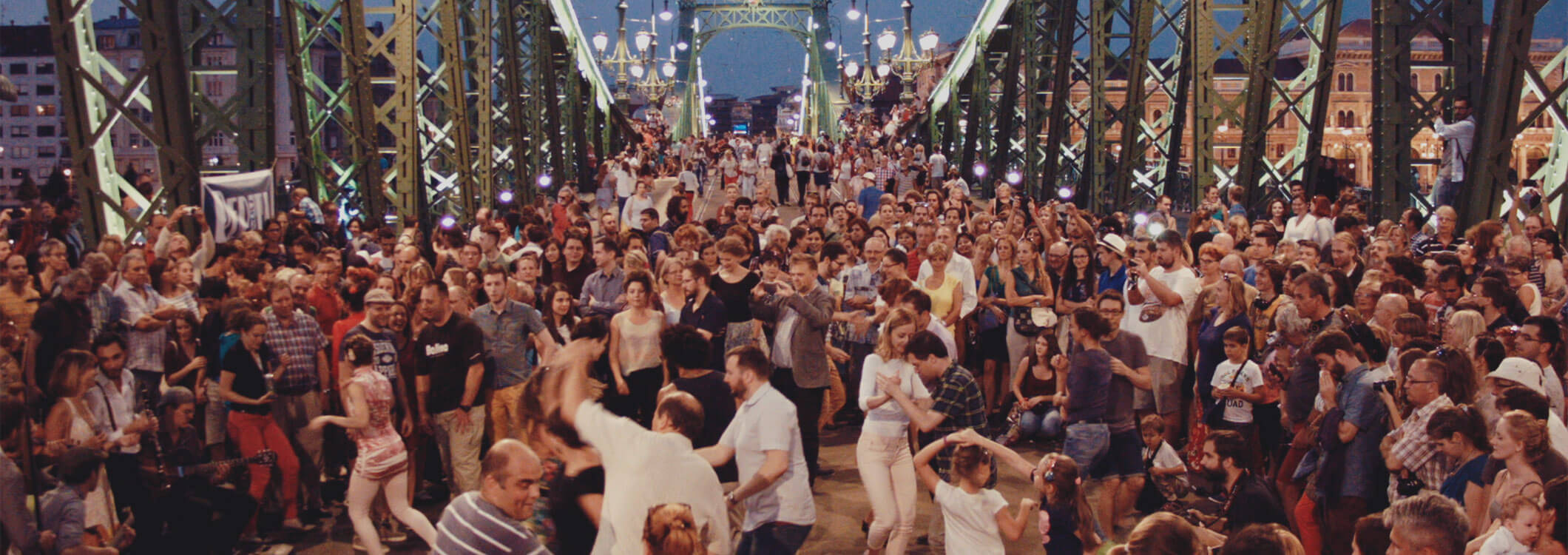 People are dancing on the Chain Bridge by night